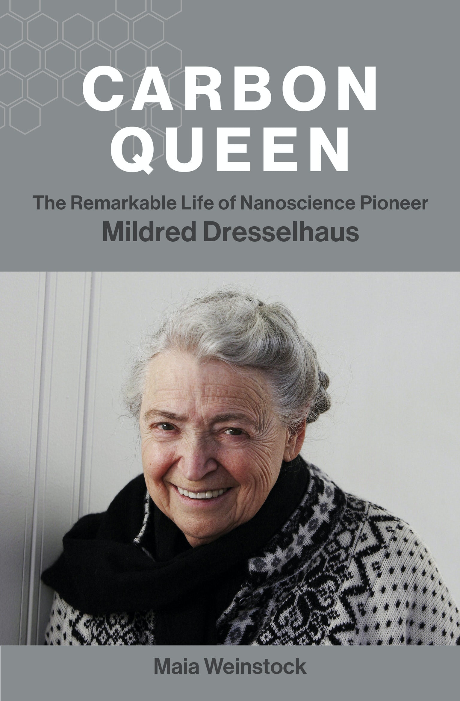 The Carbon Queen jacket is elegant gray, with a carbon molecular structure and a smiling photo of Mildred Dresselhaus, wearing her trademark black and white shawl.